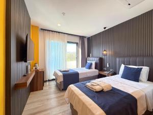 a hotel room with two beds and a television at La Bonita Marina Hotel Bodrum in Bodrum City +43 photos