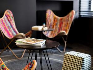 Una mesa con un libro encima al lado de sillas. en Ibis Styles Paris Gare Saint Lazare, en París