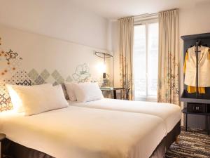 Una habitación de hotel con dos camas y una ventana. en Ibis Styles Paris Gare Saint Lazare, en París