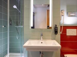 un baño con lavabo y ducha en Ibis Styles Paris Gare Saint Lazare, en París 49 fotos más