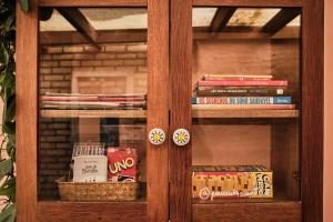 a glass cabinet with books and cookies in it at Pousada Amô in Guarda do Embaú