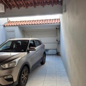 Un coche plateado aparcado delante de un garaje. en Casa aconchegante, en Franca