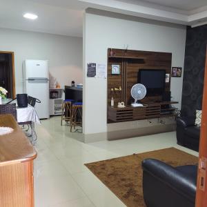 sala de estar con TV y cocina en Casa aconchegante, en Franca