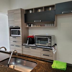 una cocina con fregadero y microondas en Casa aconchegante, en Franca