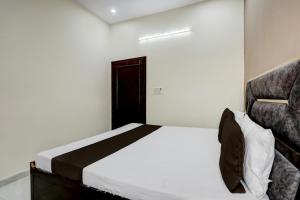 a small bedroom with a bed and a chair at Hotel O The Happy Homestay in Morādābād