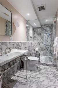 a bathroom with a toilet and a sink and a shower at Massive NYC Brownstone with Patio in New York