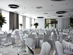 a banquet hall with white tables and chairs at ibis styles Grudziadz in Grudziądz