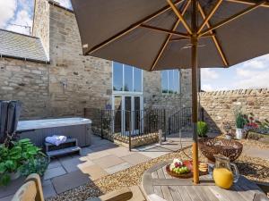 a table with an umbrella on a patio at The Granary - Uk40457 in Newsham
