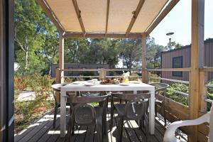a patio with a table and chairs on a deck at Camping Bella Vista in Calvi