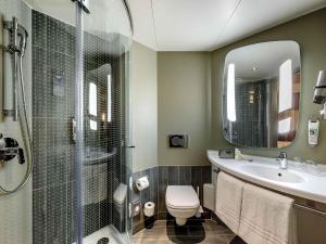 Un baño con inodoro, lavabo y ducha. en ibis Wien Hauptbahnhof, en Viena 70 fotos más