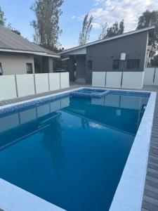 a swimming pool with blue water in front of a house at Finozest Apartments in Ndola