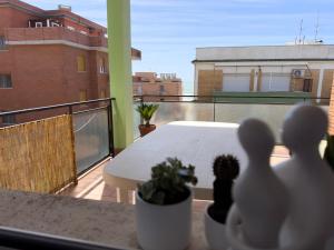 un balcón con una mesa blanca y macetas en Piccola Vietri, en LʼAmericano