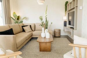 ein Wohnzimmer mit einer Couch und einem Couchtisch in der Unterkunft Watervilla binnenhaven met Sauna | 6 personen - Boutique Parc Pharshoeke in Heeg