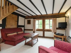 a living room with a red couch and a table at Parkers in Mathon
