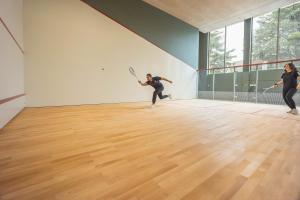 two people in an empty room playing with a tennis racket at Babel Community Hôtel Lille - Villeneuve d'Ascq in Villeneuve d'Ascq