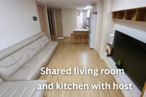a living room with a white couch and a kitchen at Vivy1 in Busan