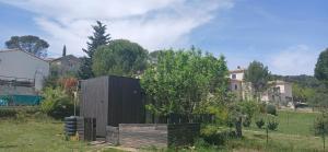 a black box in a yard with a tree at Studio clim 4-5 pers animaux, mai oct spa et piscine in Saint-Ambroix