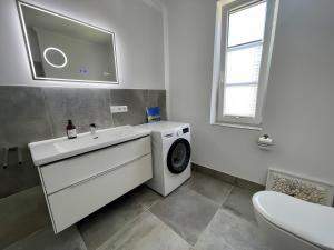 a bathroom with a washing machine and a sink at Fewo-meerblick-Rügen in Altefähr +30 photos