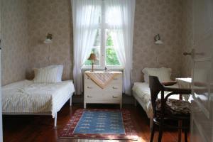a bedroom with two beds and a desk and a window at Greby Bed & Breakfast in Räpplinge