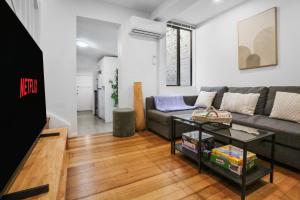 a living room with a couch and a table at Pyrmont NSW - 3 Bedroom Apartment- 8 Guests - NetFlix in Sydney