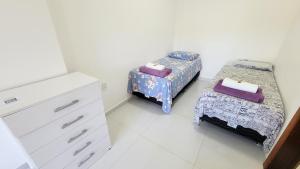 two beds in a room with a dresser and a bedroom at Pousada e Suítes Ecologia Lençóis in Lençóis +52 photos