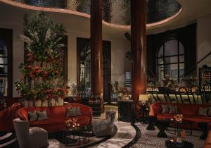 a lobby with red couches and flowers in a building at One Aldwych in London