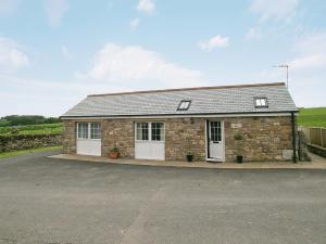 a small brick building with white doors and aphaltphaltphaltphalt at The Fauld in Gilsland