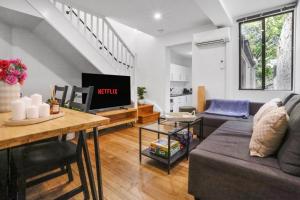 a living room with a couch and a table at Pyrmont NSW - 3 Bedroom Apartment- 8 Guests - NetFlix in Sydney +8 photos