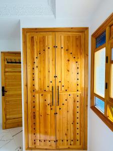 a wooden door in a room with a window at Oualidia Holiday, Apartment 4 in Oualidia