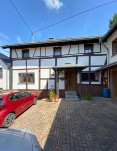 a red car parked in front of a house at Auszeit Ferienhaus Nr 2 in Sierscheid