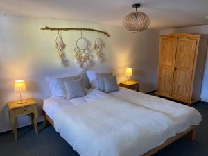 a bedroom with a large white bed with two lamps at Auszeit Ferienhaus Nr 2 in Sierscheid