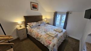 a bedroom with a bed with towels on it at Pepperpot in Portreath