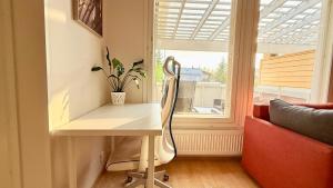 a desk and a chair in a room with a window at Oulu Modern 2BR with Sauna, Patio and Parking, 10 min to Center in Oulu