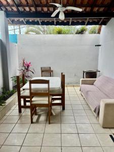 a patio with a table and chairs and a bed at Kandui Flats Maresias in Maresias