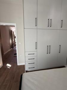a bedroom with white cabinets and a mirror at Grandpa's House in Pídhima +9 photos