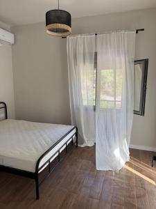 a bedroom with a bed and a large window at Grandpa's House in Pídhima