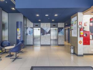 a lobby of a hospital with chairs and elevators at ibis budget Blumenau in Blumenau