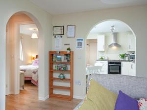 a living room and kitchen with an archway in a room at Challette At Timbertops in Washfield