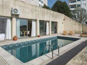 a swimming pool in front of a building at Dom Carlos Villa in Vila Nova de Gaia