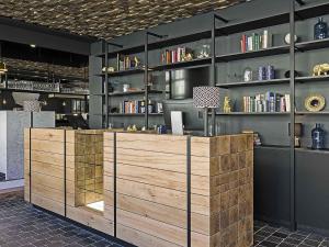 Una biblioteca con un mostrador de madera y estantes con libros. en ibis Styles Laval Centre Gare, en Laval
