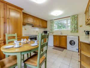 a kitchen with a wooden table and chairs and a kitchen with a washing machine at Steep Holm in Kington