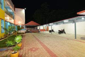 a building with two motorcycles parked in a parking lot at Thilo Guest House Auroville in Auroville