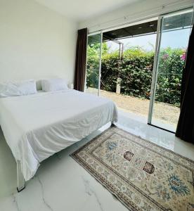 Salad Beach Bungalow - Sunset Seaview 2 bedroom في سالاد بيتش: غرفة نوم بها سرير ونافذة وسجادة