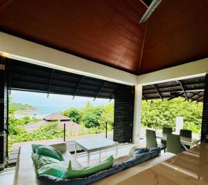 Salad Beach Bungalow - Sunset Seaview 2 bedroom في سالاد بيتش: غرفة معيشة مفتوحة مع طاولة وكراسي