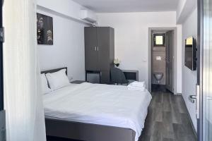 a bedroom with a large white bed in a room at Lizubert in Afumaţi