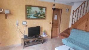 a living room with a television and a staircase at ÉTAGES PRIVÉE POUR 4 PERSONNES 2 CHAMBRES ET 1 SALE DE BAIN i in Roissy-en-France