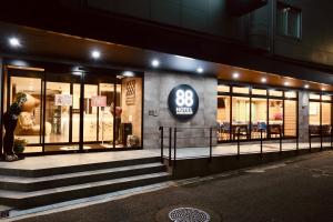 a woman standing outside of a store at night at Hotel 88 Shinsaibashi in Osaka