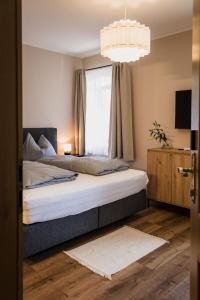 a bedroom with a bed with a window and a chandelier at LINDENGUT - Boutique Hotel nahe IKUNA Park in Natternbach