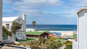 a view of the beach from the balcony of a house at The Sandcastle - Apartment in Villa in Witsand