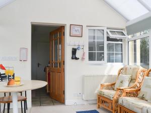 a living room with a table and a chair at Mavis Cottage in Kington